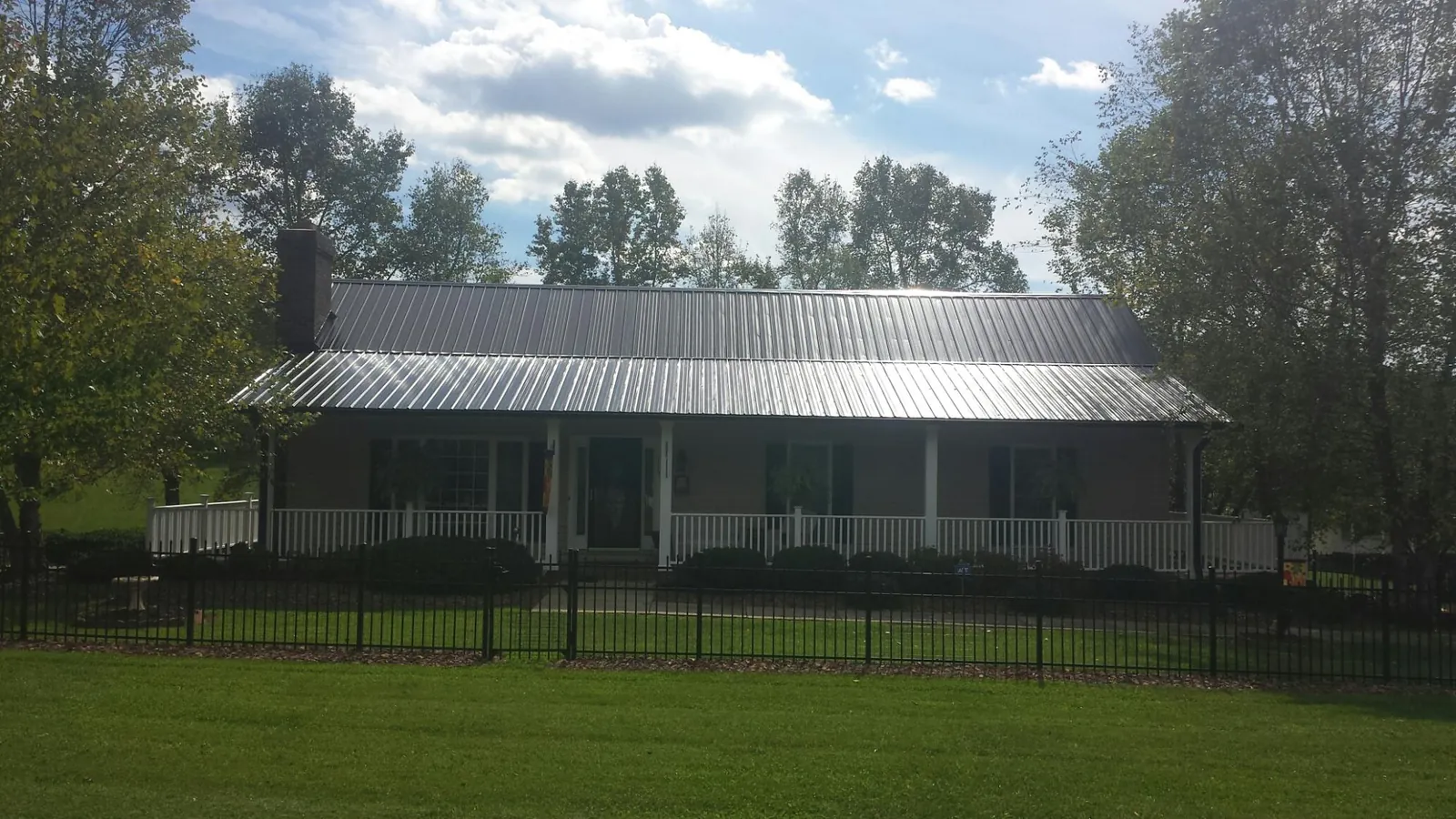 Gray metal roof on a brick ranch with a full width front porch in New Ulm