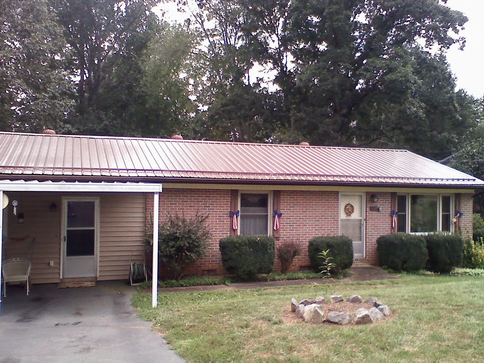 Bronze metal roof and carport on a brick ranch home — Roof Repair work by our crew in New Ulm